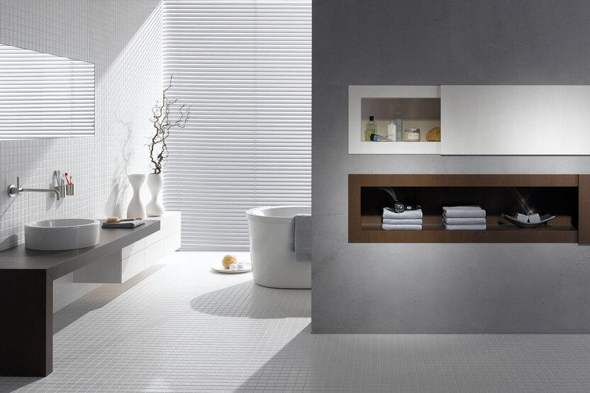 Badezimmerimpression mit stilvoller Trennwand mit Einbauregal.