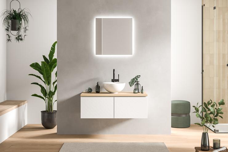 Minimalistisch designtes Bad nach Maß mit schwebendem Waschtisch in Weiß, beleuchtetem Spiegel und grünen Pflanzendetails.